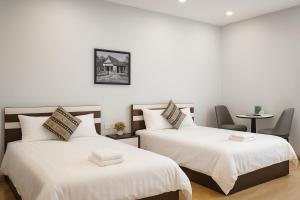 two beds in a room with white walls at Eco Nest Hotel 6 Đình Ngang in Hanoi +4 photos