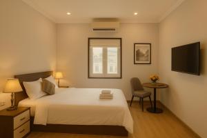 a bedroom with a bed and a table and a television at Eco Nest Hotel 6 Đình Ngang in Hanoi