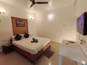 a bedroom with a bed with a flat screen tv at Jackfruit in Arambol