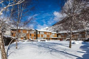 a building in the snow with trees in the foreground at Tierra de Biescas in Biescas