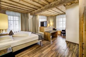 a hotel room with a bed and a television at Hotel Goldener Adler, BW Signature Collection in Innsbruck
