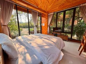a bedroom with a bed in a room with windows at Love hill than Uyên in Bản Kiem