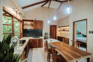 a kitchen with a wooden table and a dining room at Marevka - Pool Villa with garden in General Luna