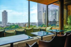 a balcony with tables and chairs and a view of the city at Hyatt Regency Tokyo in Tokyo