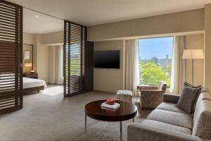 a living room with a couch and a bed and a table at Hyatt Regency Tokyo in Tokyo