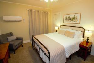 a bedroom with a large bed and a chair at The Cabin at Deer Hollow in Three Rivers +42 photos