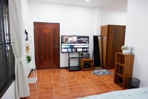 a room with a television and a tiled floor at Pran Botanica Private Pool Villa in Ban Rom Pho