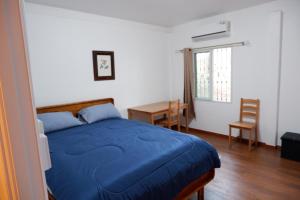 a bedroom with a blue bed and a table at Pran Botanica Private Pool Villa in Ban Rom Pho +48 photos