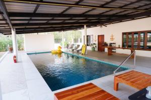 a swimming pool in the middle of a house at Pran Botanica Private Pool Villa in Ban Rom Pho