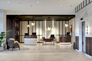 a lobby with chairs and a table in a building at Hilton Gdansk in Gdańsk