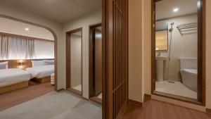 a bedroom with a bed and a bathroom with a tub at Maison The Denbasta Hotel in Busan +91 photos