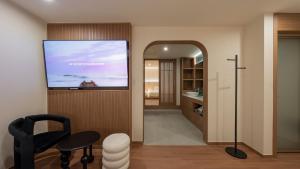 a living room with a large mirror and a television at Maison The Denbasta Hotel in Busan