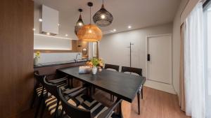 a dining room with a black table and chairs at Maison The Denbasta Hotel in Busan
