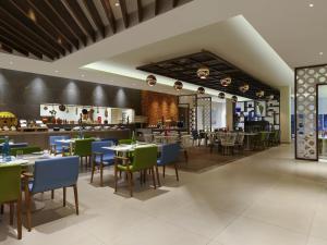 a restaurant with tables and chairs and a bar at ibis Styles Goa Calangute - An Accor Brand in Calangute
