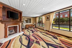 a living room with a fireplace and a tv at Quality Inn & Suites Florence Civic Center in Florence