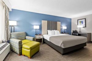 a hotel room with a bed and a chair at Quality Inn & Suites Florence Civic Center in Florence