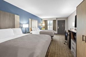 a hotel room with two beds and a flat screen tv at Quality Inn & Suites Florence Civic Center in Florence +57 photos