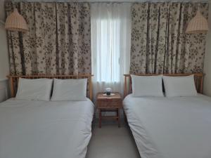 two beds in a small room with a window at 어게인수영 in Suyŏng