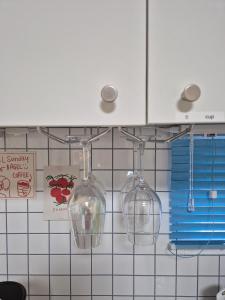 three wine glasses hanging from a kitchen cabinet at 어게인수영 in Suyŏng +21 photos
