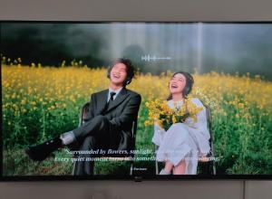 a tv screen with a man and a woman in a field at 어게인수영 in Suyŏng