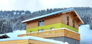 a house on a hill with snow on the ground at Ferienwohnung Sonnenschein in Balderschwang