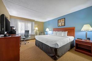 a hotel room with a bed and a desk and a television at Clarion Hotel Conference Center Lexington North in Lexington