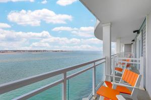 a balcony with two orange chairs on a cruise ship at Cambria Hotel Ocean City - Bayfront in Ocean City