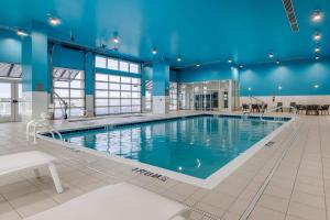 a large indoor swimming pool with blue ceilings at Cambria Hotel Ocean City - Bayfront in Ocean City