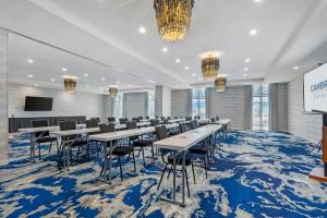 a conference room with tables and chairs on a blue carpet at Cambria Hotel Ocean City - Bayfront in Ocean City +65 photos