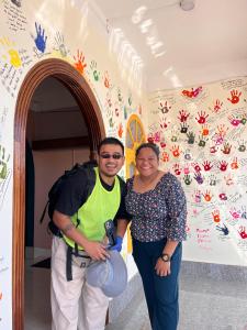 a man and a woman standing in front of a wall at Yogstel - Backpackers Hostel in Dūta