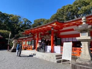 a red temple with people standing in front of it at ゲストハウス有無 in Mihama