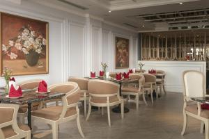 a restaurant with tables and chairs with red napkins on them at Solar Premium Hotel & Spa in Hanoi