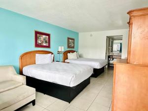 two beds in a room with blue walls at Rodeway Inn Clearwater - Central in Clearwater +24 photos