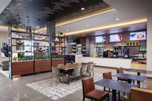 a restaurant with tables and chairs and a bar at Tempo By Hilton Manassas in Manassas
