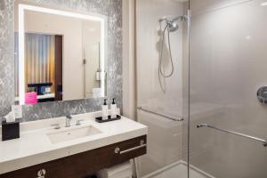 a bathroom with a sink and a shower at Tempo By Hilton Manassas in Manassas +25 photos