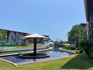 a fountain with an umbrella in the middle of a courtyard at Extra large apartment with sea view & 2 pools in Bangrak Beach