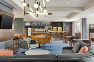 a living room with a couch and a bar at Courtyard Atlanta Suwanee in Suwanee
