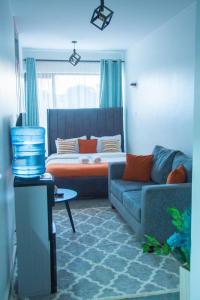 a living room with a couch and a bed at Hise Haven Stays in Kiambu