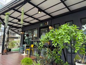 a restaurant with plants in front of a building at S Hostel Sukhumvit 48 in Bangkok