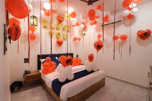 a room with a bed with orange and white balloons at Hotel Carnival in Bāghpat