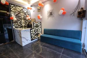 a blue couch in a room with orange balloons on the wall at Hotel Carnival in Bāghpat