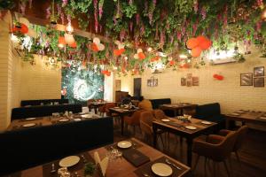 a restaurant with tables and chairs and flowers on the wall at Hotel Carnival in Bāghpat