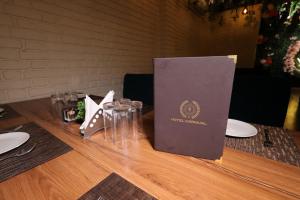 a book sitting on top of a table with glasses at Hotel Carnival in Bāghpat