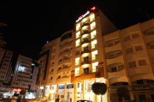 a building with lights on in a city at night at Pacha hotel in Sfax