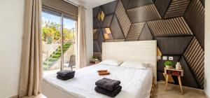 a bedroom with a large bed and a large window at Amdar Holiday Apartments in Eilat +56 photos