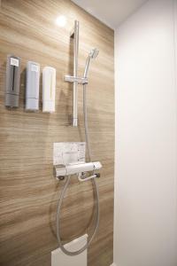 a shower in a bathroom with a hose attached to a wall at レインボーマリン in Mihama +24 photos