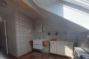 an attic bathroom with a sink and a mirror at Ferienwohnung Lechauszeit in Landsberg am Lech