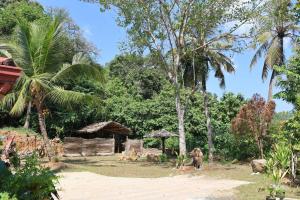 an elephant standing in front of a village with trees at Green Heaven in Dickwella