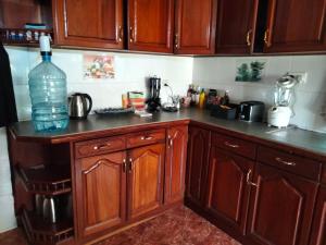 a kitchen with wooden cabinets and a large bottle of water at Hansat Homestay Residence in Arusha