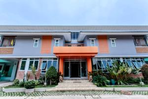a building with an orange front door and stairs at 100House Hotel Korat in Ban Hua La Loeng